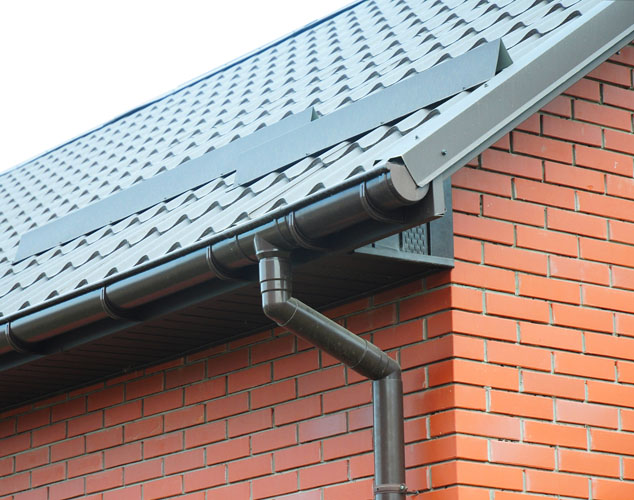 Closeup on rain gutter system and roof snow protection